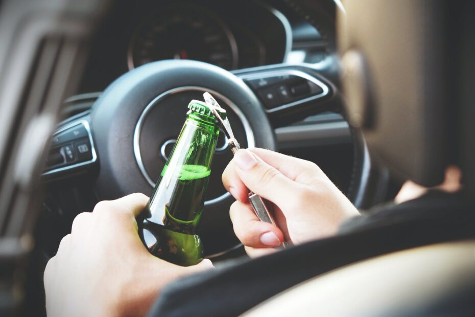 person opening bottle on car