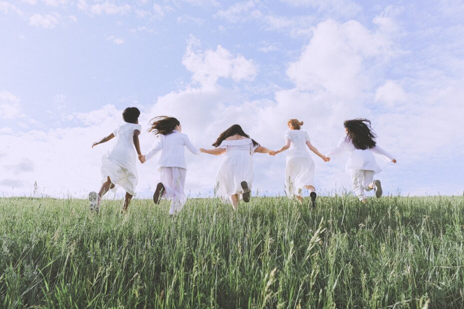 group of women running on green grass field