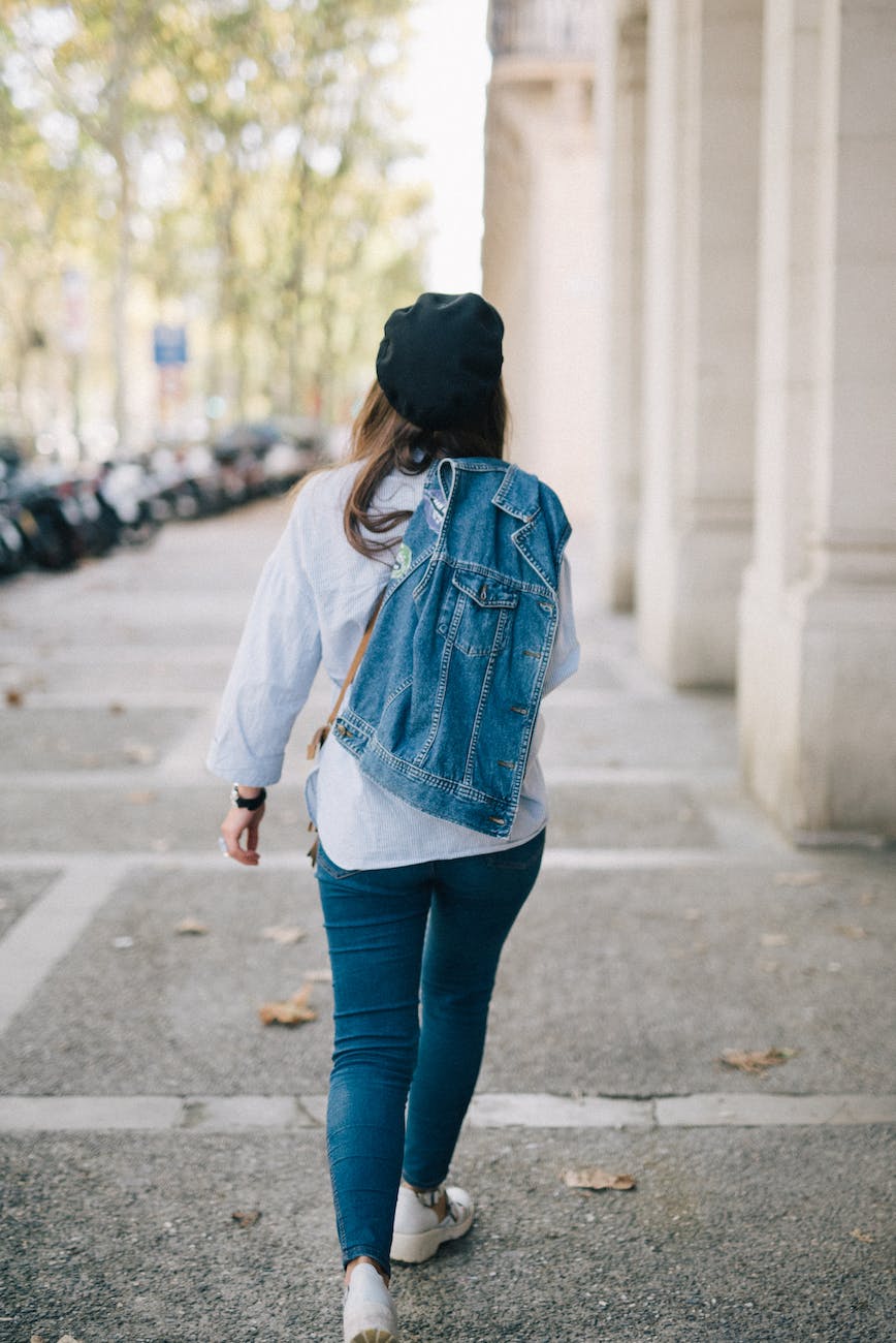back view of a person carrying a denim jacket